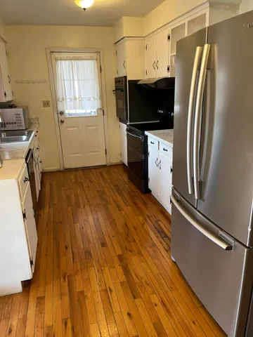 a view of a kitchen with wooden floor and electronic appliances