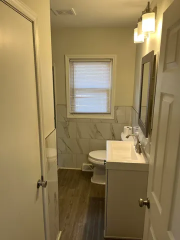 a bathroom with a sink toilet and mirror
