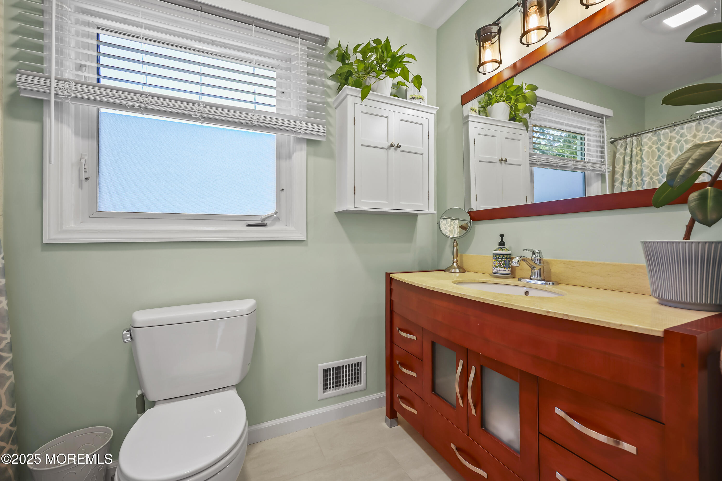22 Riley Road Morganville, NJ 07751 - Photo 23 of 28 a bathroom with a toilet a sink and a mirror