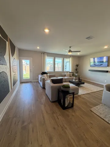 a living room with furniture and a wooden floor