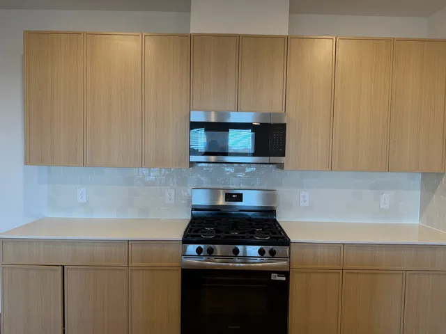 a kitchen with granite countertop a stove top oven microwave and cabinets