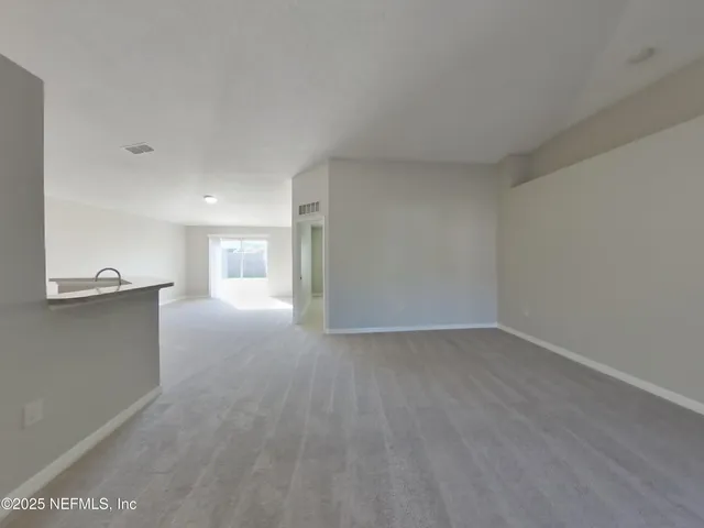 a view of a big room with wooden floor and a window