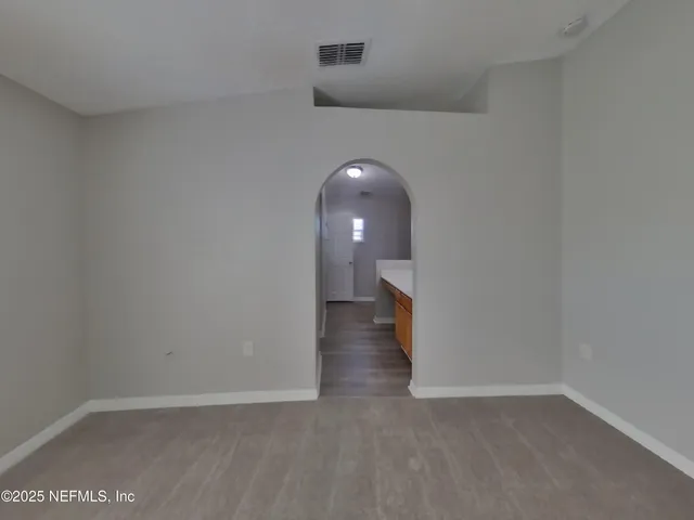 a view of a room with wooden floor and a ceiling fan