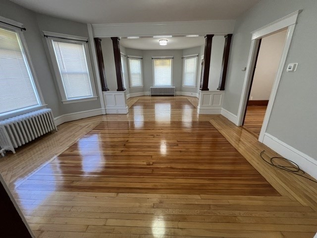 a view of a hallway with wooden floor and staircase