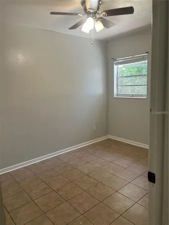 an empty room with a chandelier fan