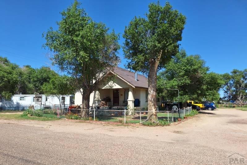 503 Division Street Lamar, CO 81052 - Photo 9 of 11 a backyard of a house with table and chairs under an umbrella