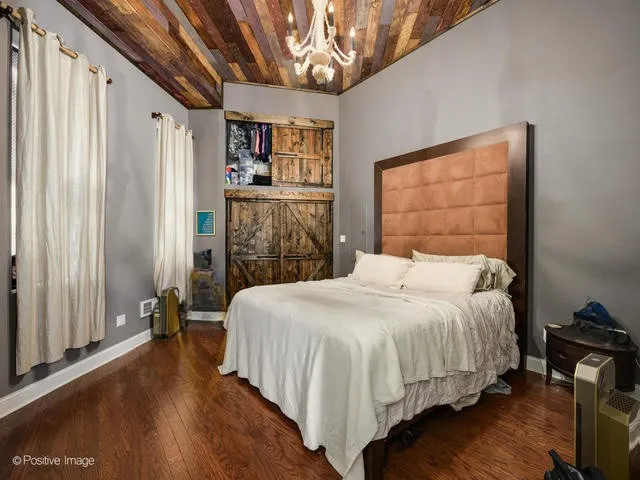 a bedroom with a large bed and a chandelier