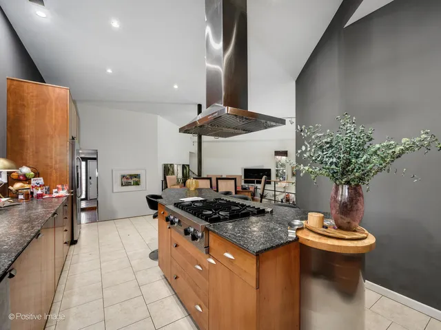 a kitchen with stainless steel appliances granite countertop a sink a stove and a wooden floors