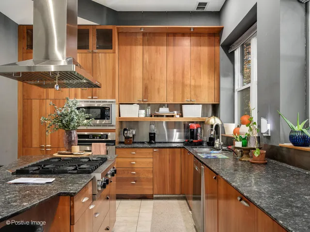 a kitchen with stainless steel appliances granite countertop a stove a sink and a microwave