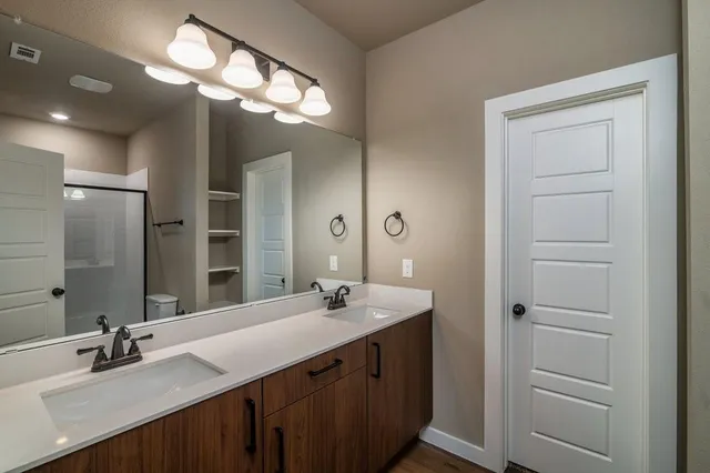 a bathroom with a double vanity sink and a mirror