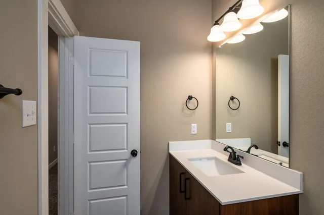 a bathroom with a sink vanity and a mirror