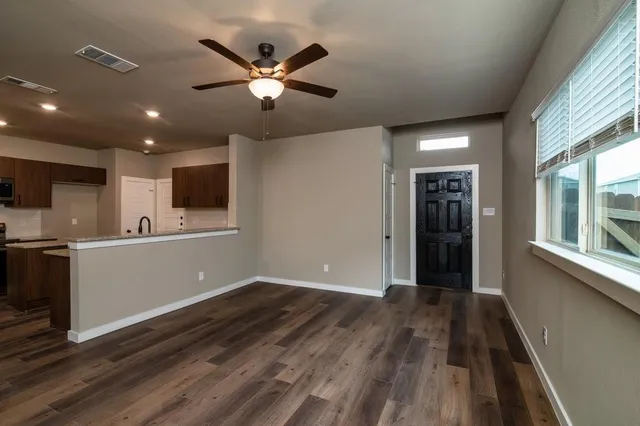 a view of room with window ceiling fan and hardwood floor