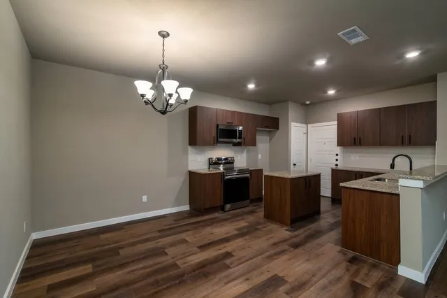 a kitchen with stainless steel appliances granite countertop a sink stove and refrigerator