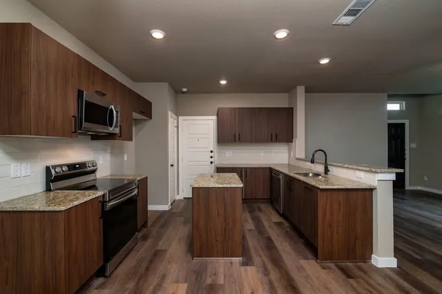 a kitchen with stainless steel appliances a stove sink microwave and cabinets