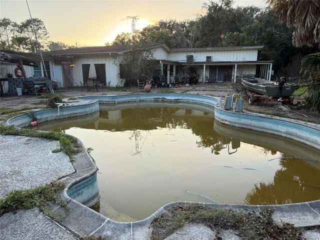 a view of a house with pool yard and a chairs