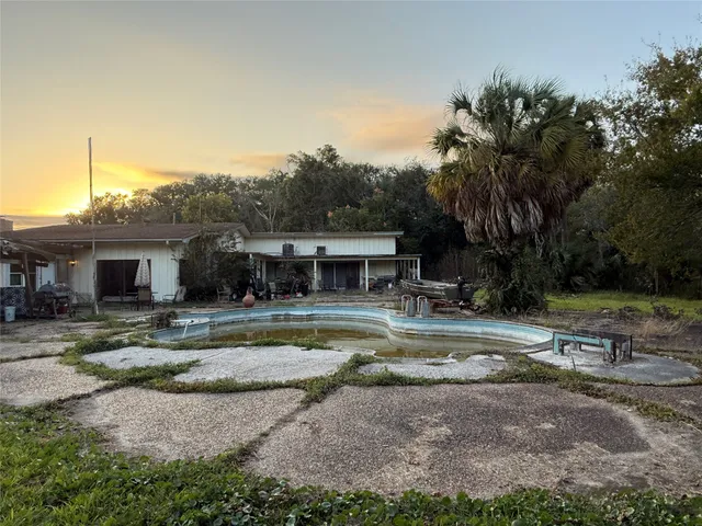 a view of a house with backyard and sitting area
