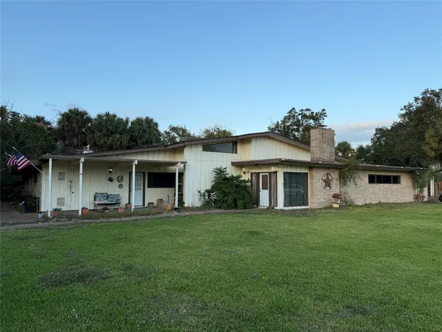 a front view of a house with a yard and trees