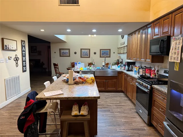 a kitchen with granite countertop a sink stove and cabinets