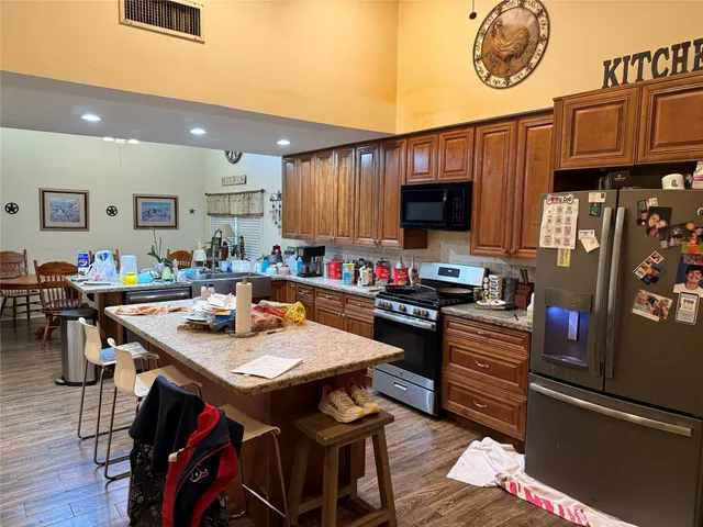 a open kitchen with granite countertop a stove and a wooden floor