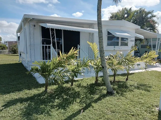 a view of a house with a yard and sitting area