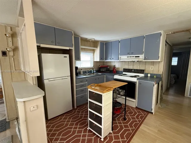 a kitchen with a refrigerator a stove a sink and a counter space
