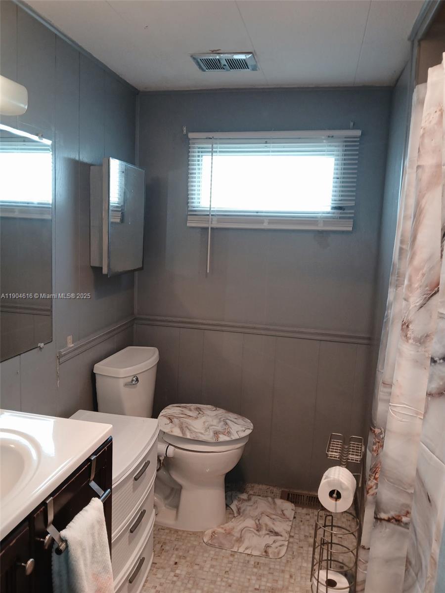1860 Southwest 83rd Terrace Davie, FL 33324 - Photo 7 of 12 a bathroom with a toilet sink and mirror