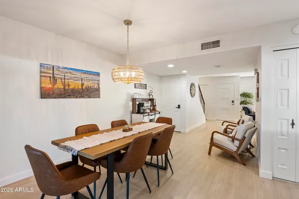 a view of a dining room with furniture a rug and wooden floor