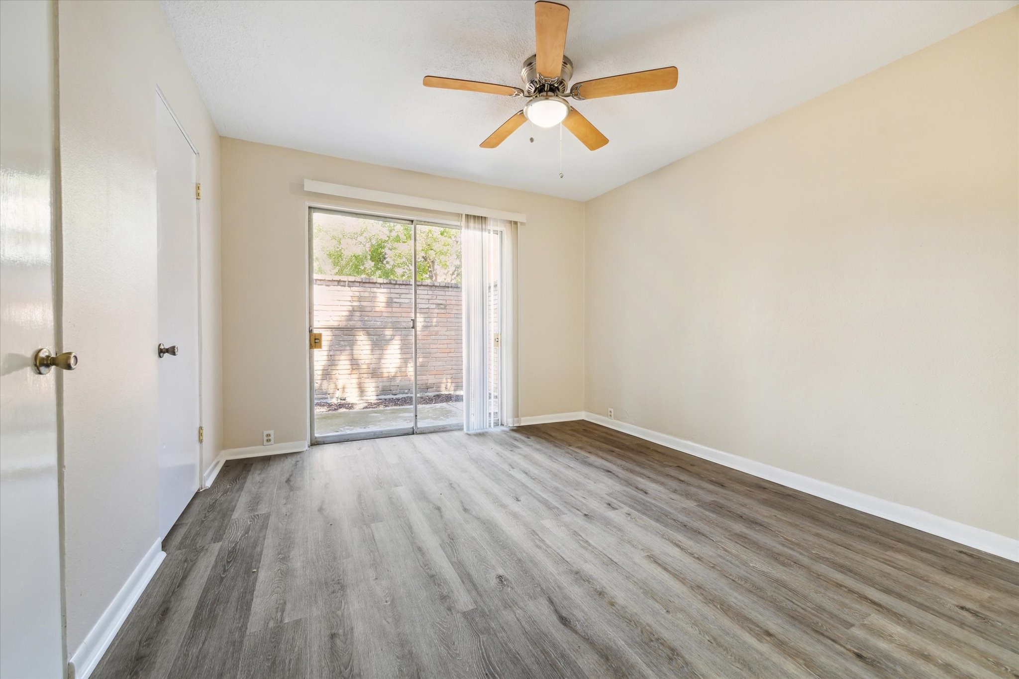 3259 Branard Street, Unit 7 Houston, TX 77098 - Photo 7 of 10 an empty room with wooden floor fan and windows