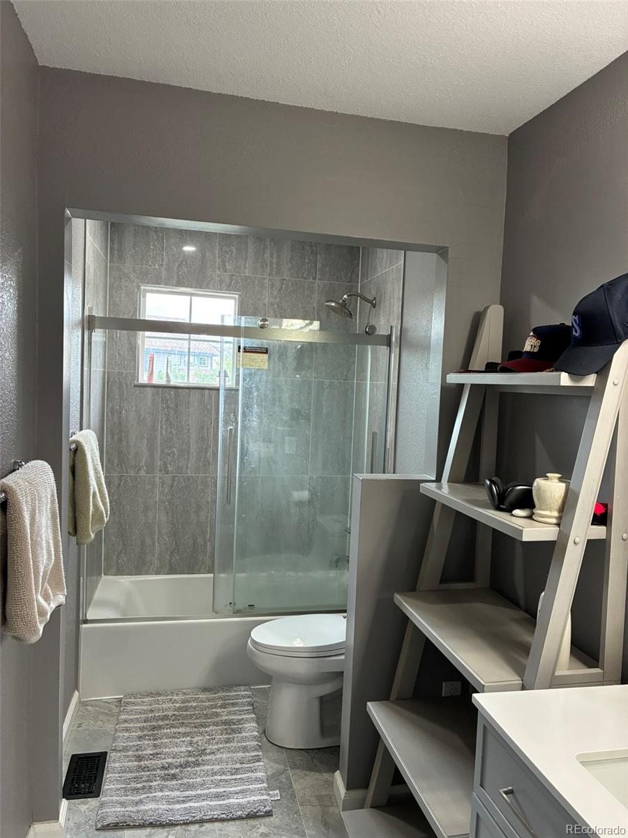 7242 South Rome Street Aurora, CO 80016 - Photo 16 of 33 a bathroom with a toilet and a shower