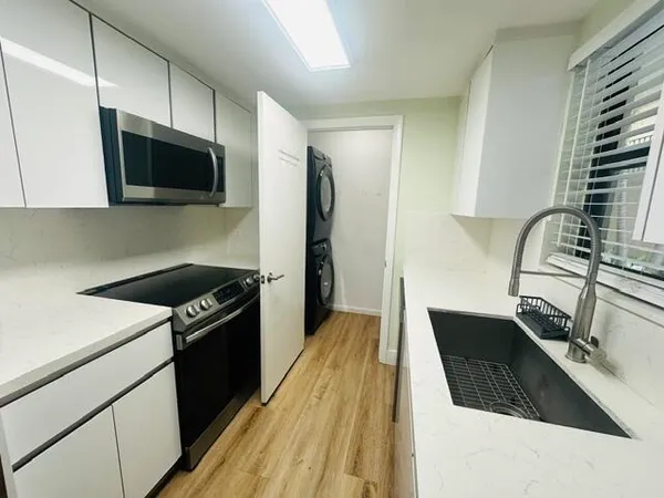 a kitchen with a sink a microwave a stove and refrigerator