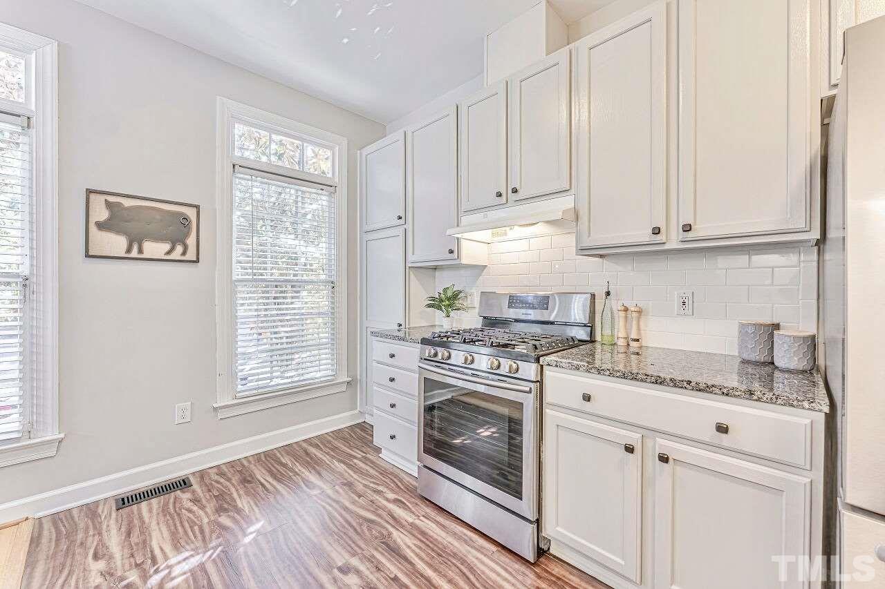 125 Fenner Lane Raleigh, NC 27603 - Photo 14 of 30 a kitchen with granite countertop white cabinets and white appliances