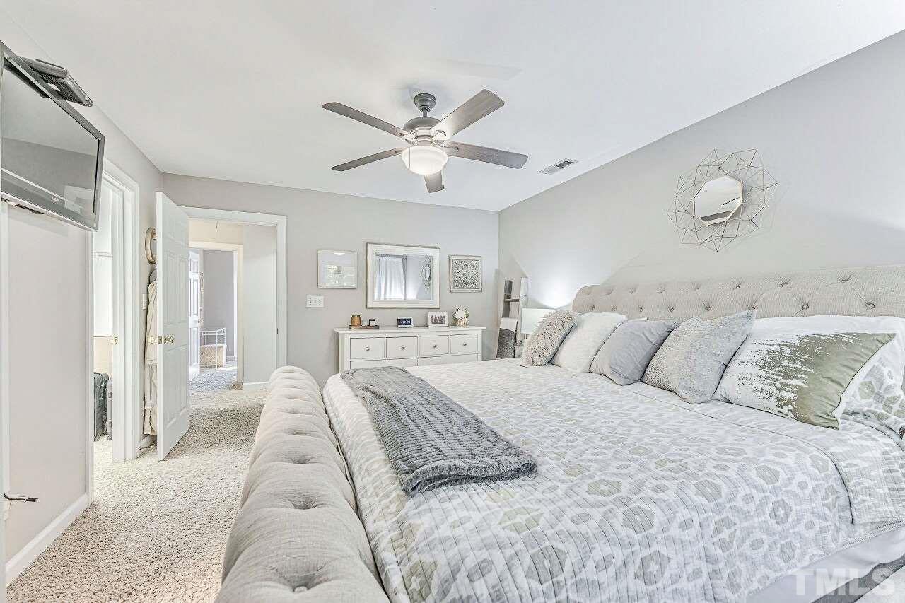 125 Fenner Lane Raleigh, NC 27603 - Photo 21 of 30 a large bedroom with a large bed and a chandelier