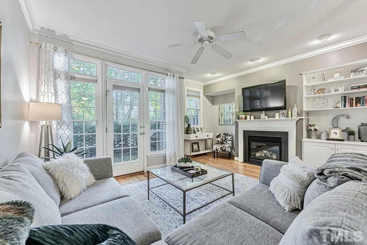 125 Fenner Lane Raleigh, NC 27603 - Photo 4 of 30 a living room with furniture a fireplace and a flat screen tv