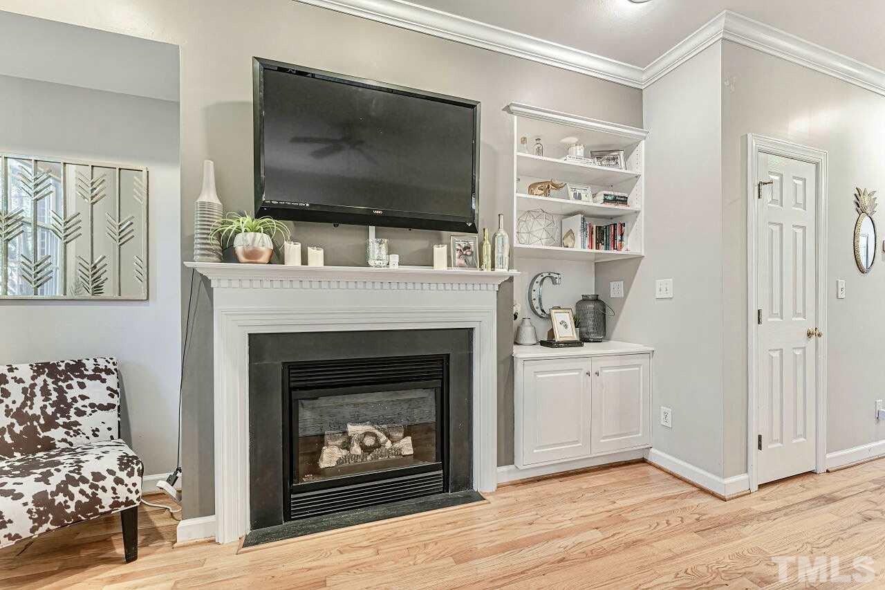 125 Fenner Lane Raleigh, NC 27603 - Photo 8 of 30 a living room with a fireplace and a flat screen tv