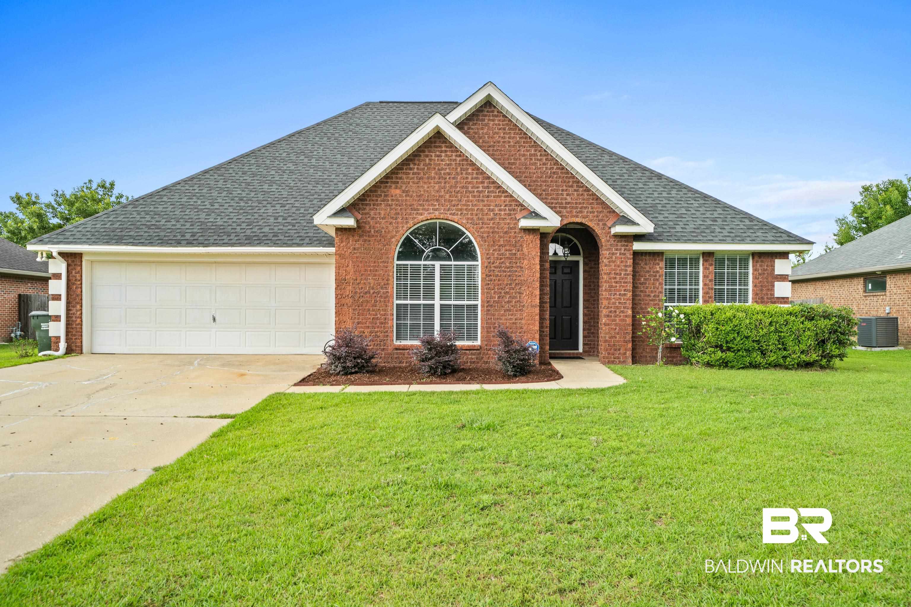 9552 Collier Loop Daphne, AL 36526 - Photo 2 of 28 View of front of home featuring central AC, brick siding, an attached garage, concrete driveway, and a front lawn