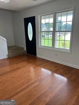 a view of a room with wooden floor and window