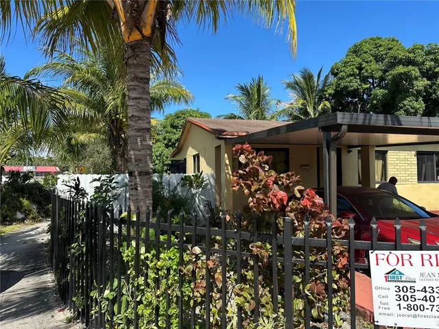 a view of a house with a tree and flower garden