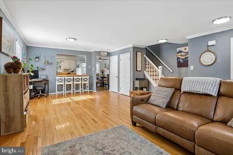 a kitchen with stainless steel appliances kitchen island granite countertop a refrigerator a stove a sink dishwasher and white cabinets with wooden floor