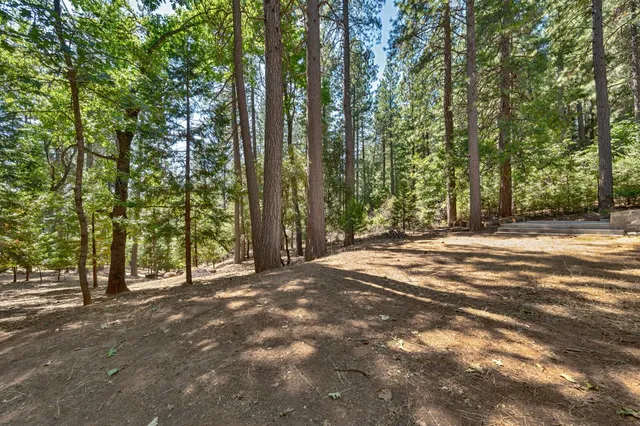 a view of a patio with table and chairs with wooden floor and fence