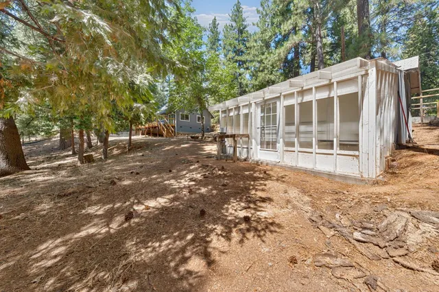a front view of a house with a yard and large tree
