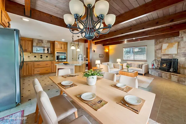 a view of a dining room with furniture a chandelier and wooden floor