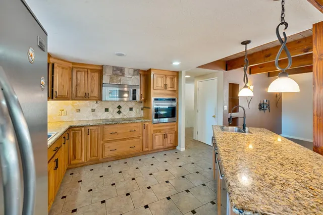 a kitchen with granite countertop a sink and cabinets