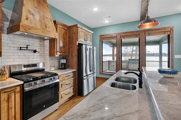 a kitchen with stainless steel appliances granite countertop a stove a sink and a refrigerator