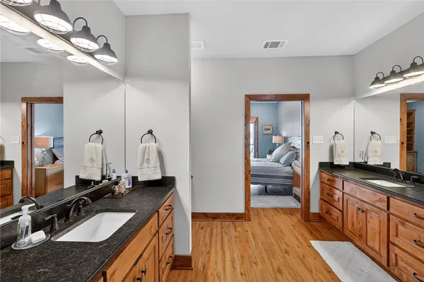 a bathroom with a granite countertop sink a mirror and shower