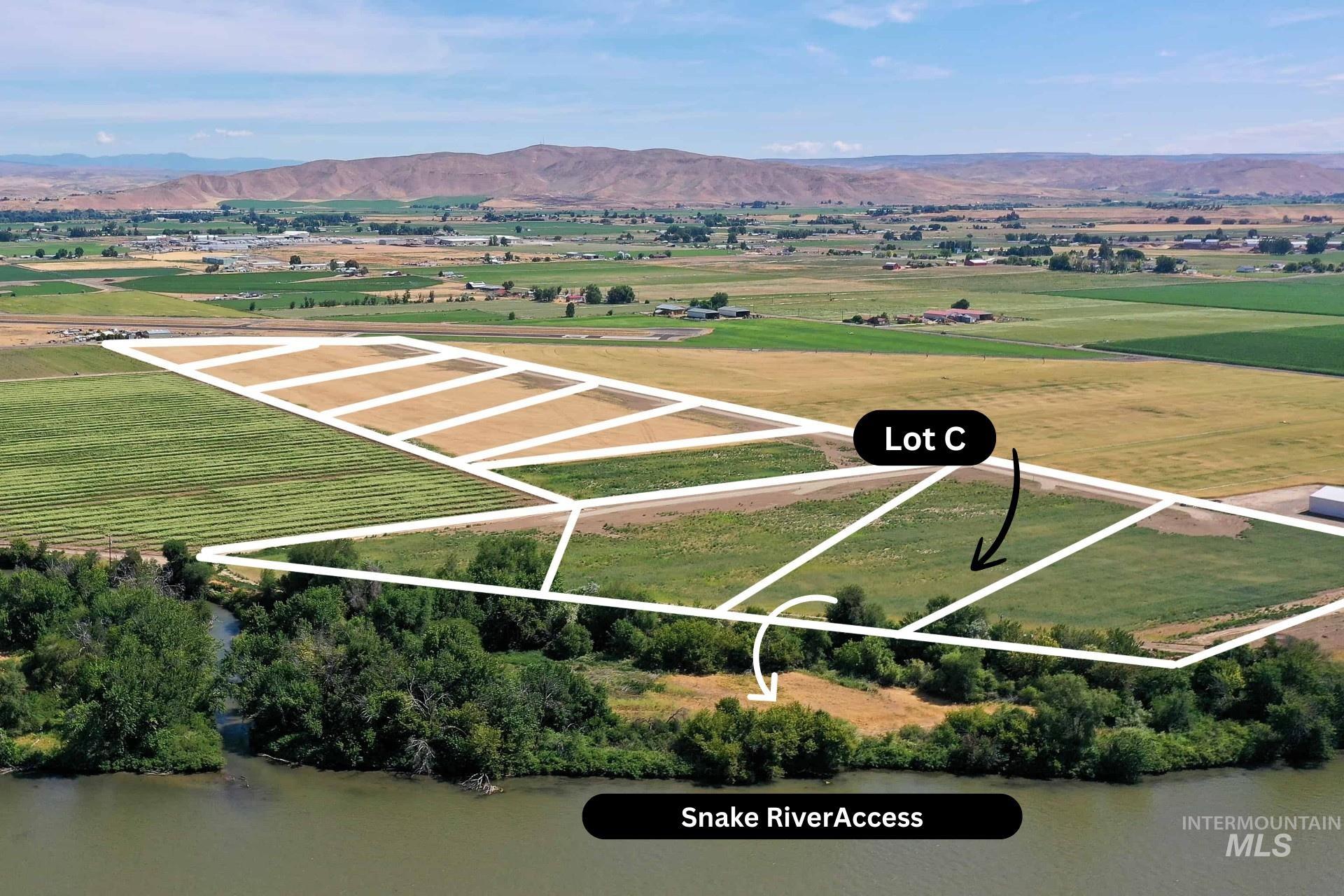 Aerial view of sparsely populated area with property boundaries highlighted and a mountainous background