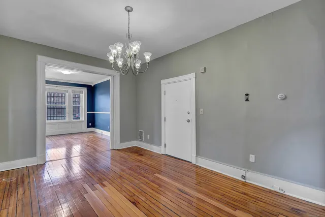 a view of a room with wooden floor and chandelier