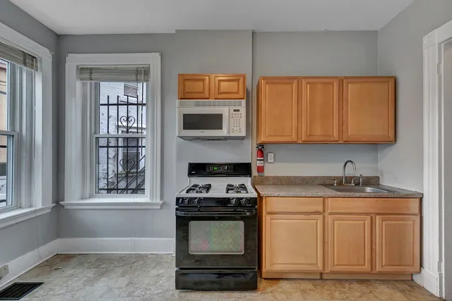 a kitchen with granite countertop a stove a sink and a microwave