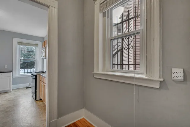 a view of a room that has a window and wooden floor