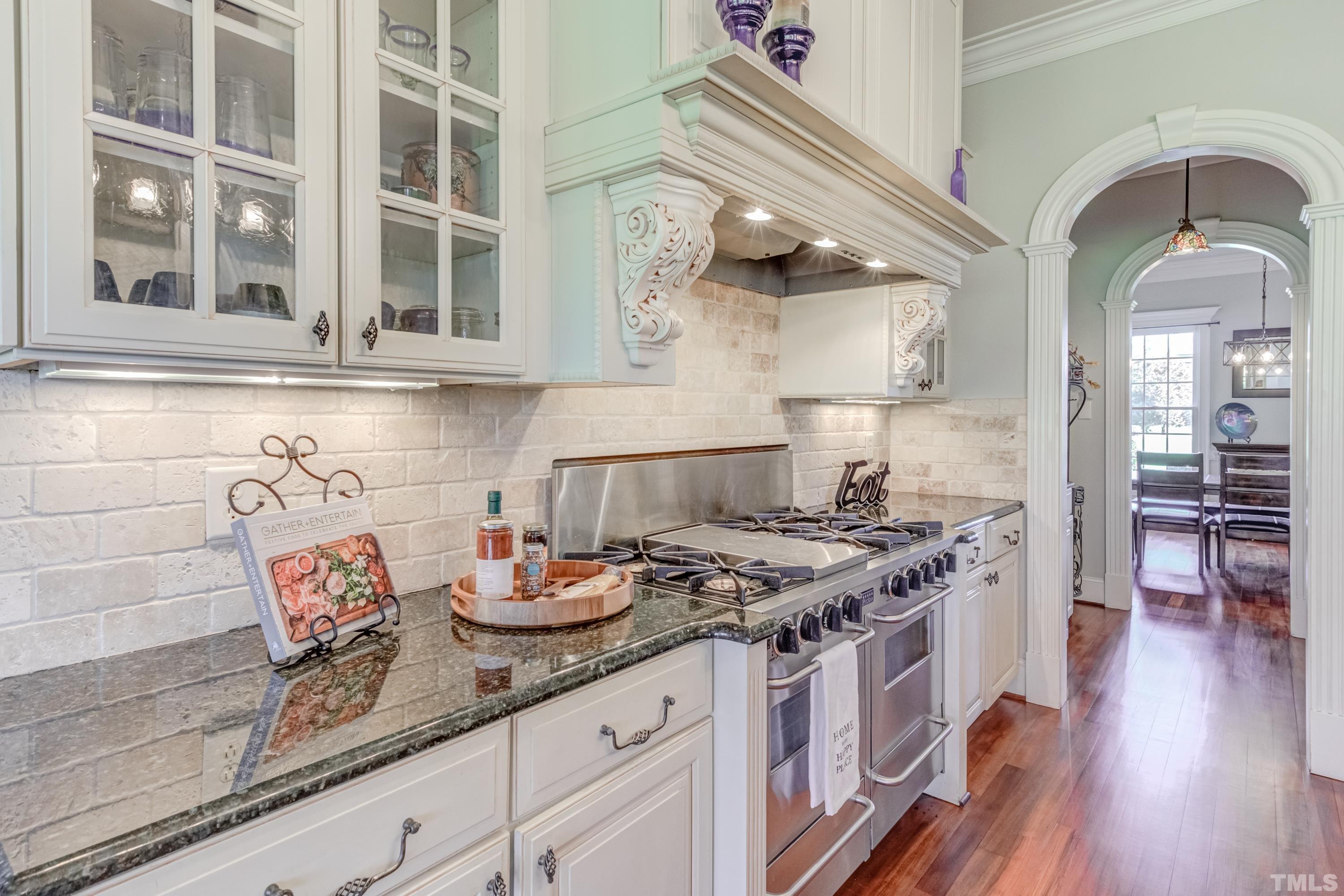 6437 Wakefalls Drive Wake Forest, NC 27587 - Photo 18 of 76 a kitchen with stainless steel appliances granite countertop a stove and a wooden floors