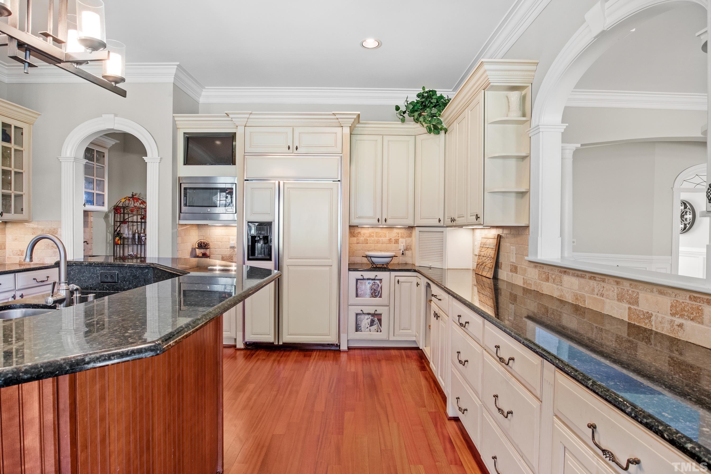6437 Wakefalls Drive Wake Forest, NC 27587 - Photo 19 of 76 a large kitchen with stainless steel appliances granite countertop a lot of counter space and wooden floor